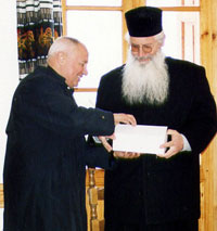 Pfarrer Brabeck überreicht das Begrüßungsgeschenk an Abt Georgios